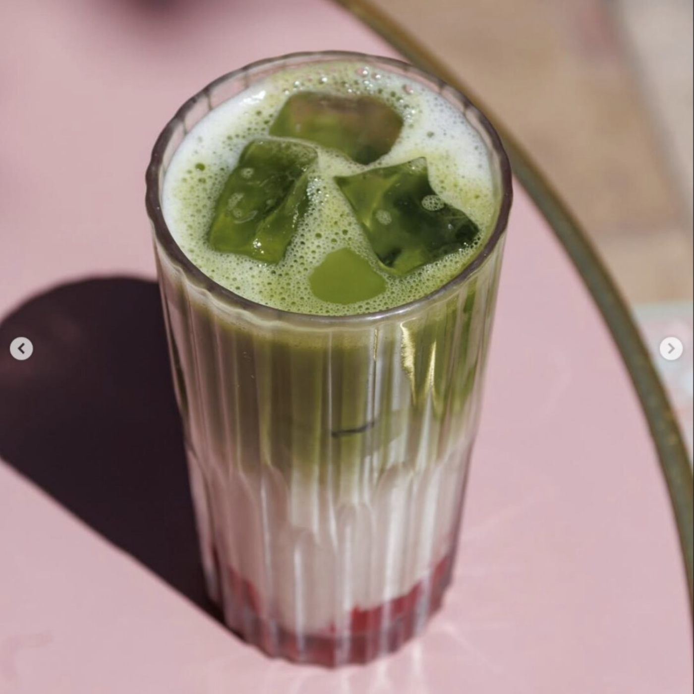 Iced matcha latte sur table rose